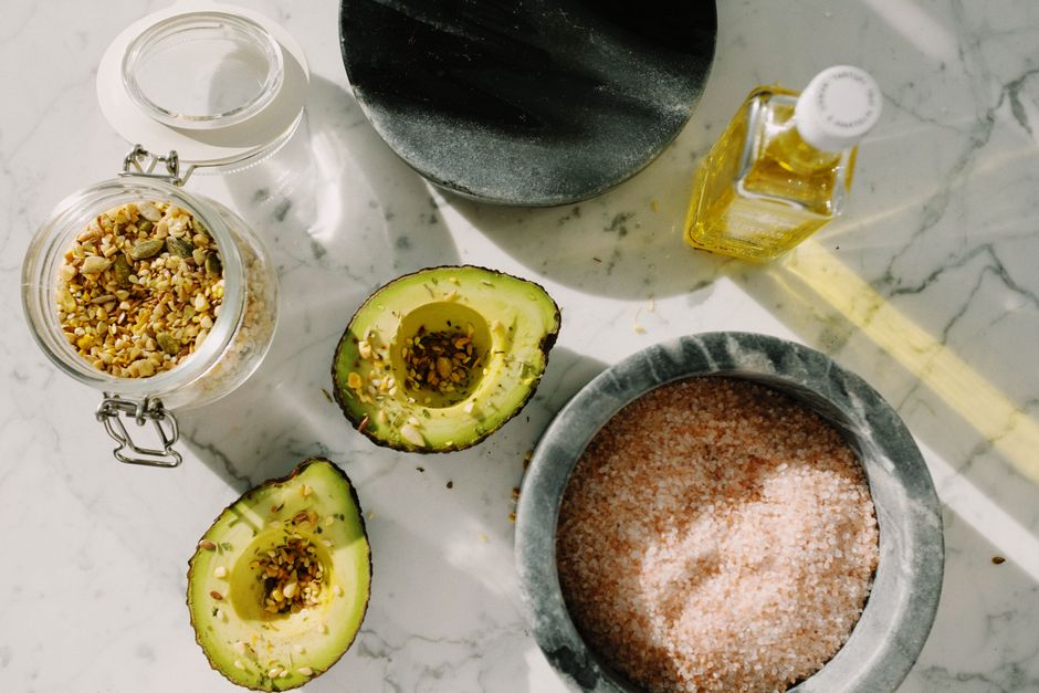 Avocadohalvdele og andre kilder til sundt fedt anrettet på et bord