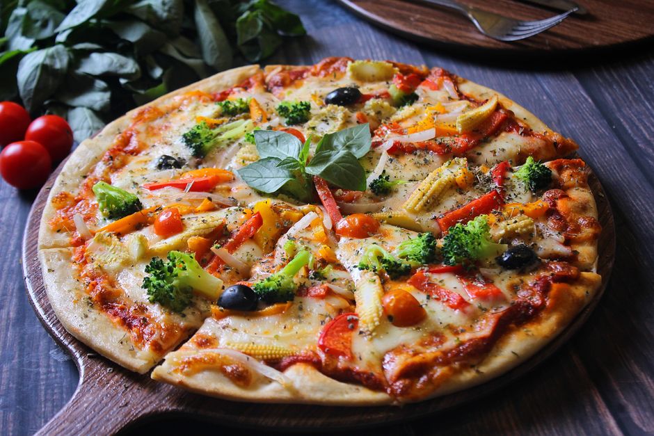 Delicious homemade vegetable pizza with fresh toppings including broccoli, olives, and tomatoes