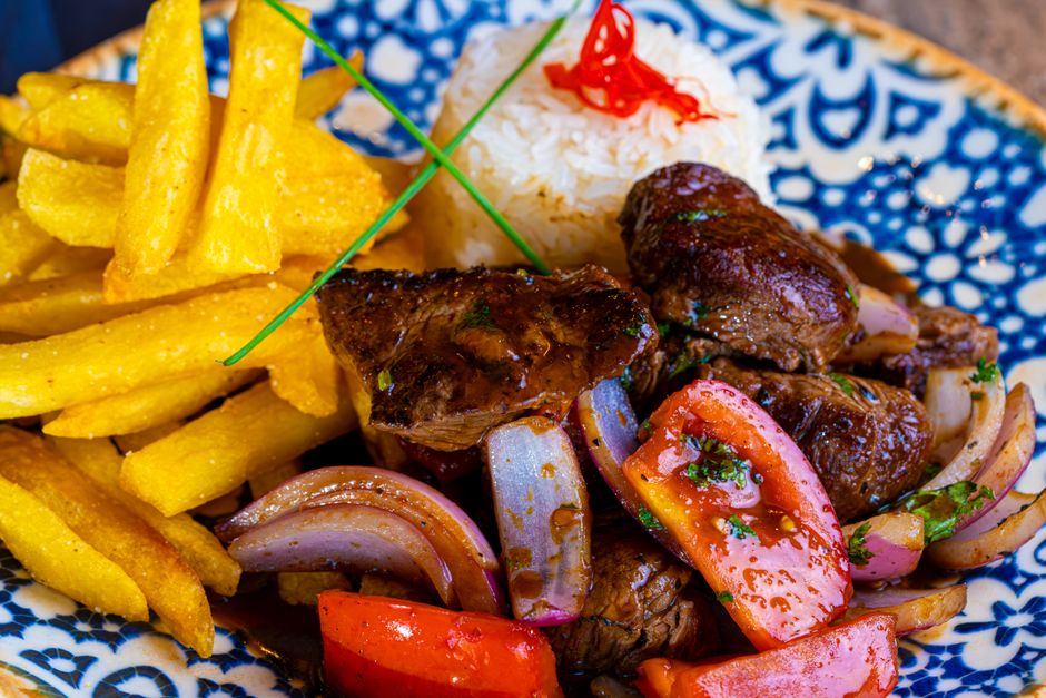 A plate of rice, fries, and seared beef, common sources of dietary carbohydrate