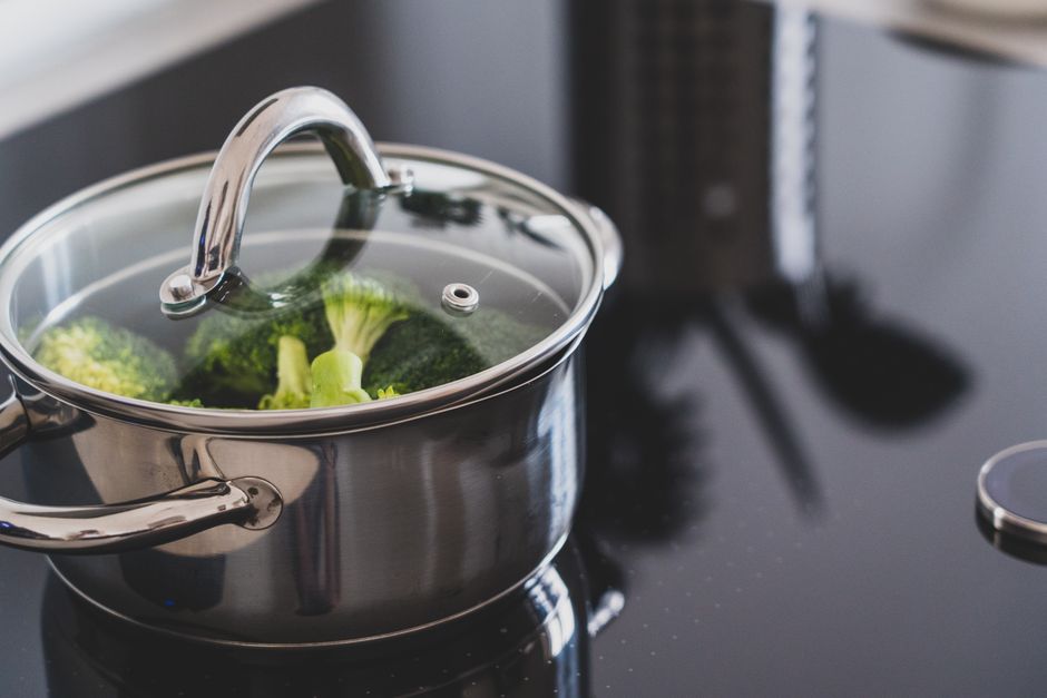 Broccoli, der dampes i en tildækket gryde af rustfrit stål