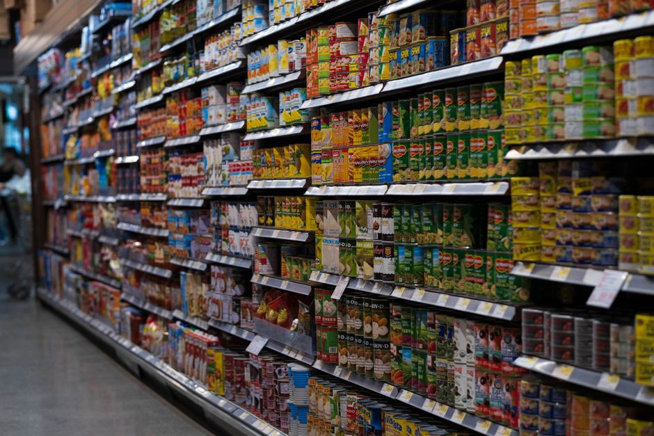 Rows of canned goods stacked on grocery store shelves